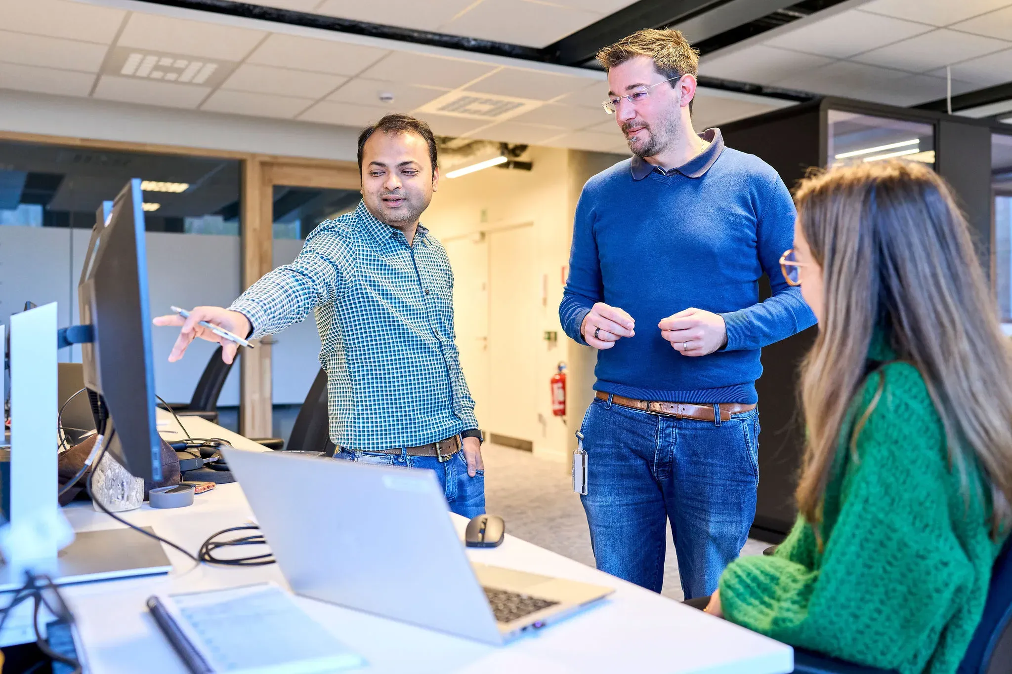 Picture of UCB employees discussing data on a computer